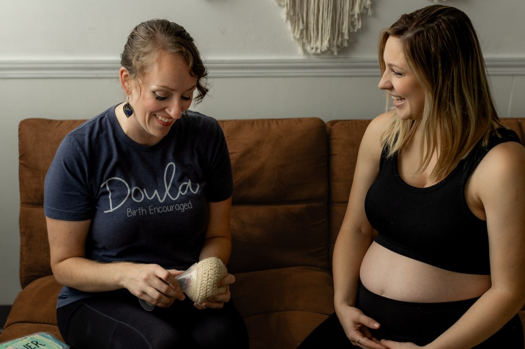 Doula demonstrating how to attach a breast pump to a breast model for a pregnant woman Ronae Cleland demonstrates how to attach a breast pump to a breast model during a lactation consultation with a pregnant mother.